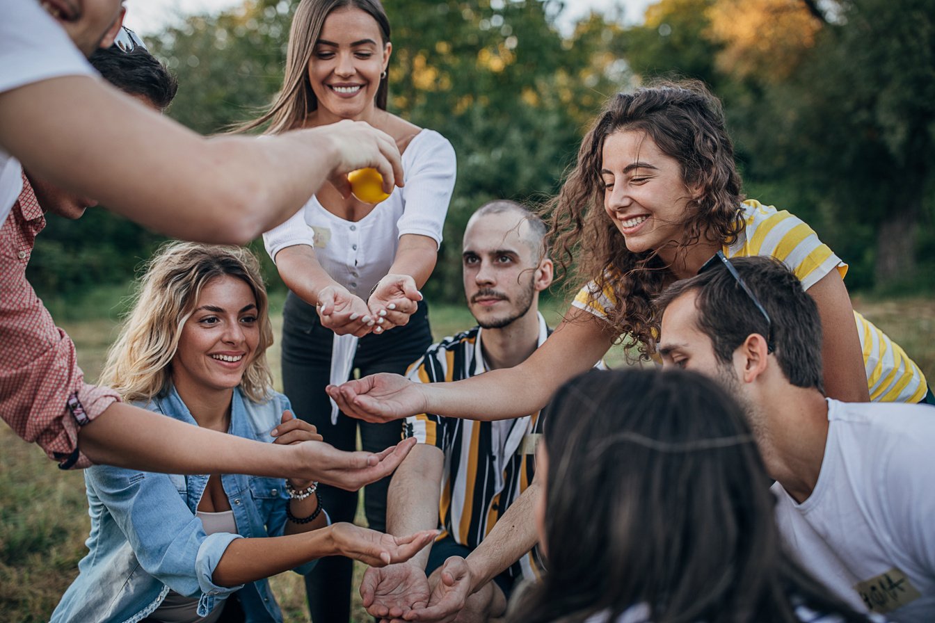 Group of friends having fun playing games on team building in nature